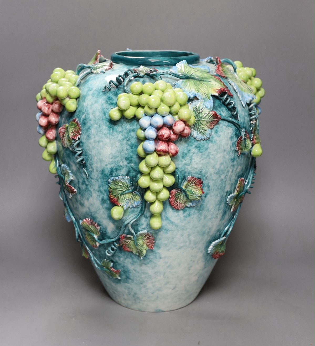 A large late 19th/early 20th century Continental polychrome glazed ‘grape vine’ vase, 39cm tall
